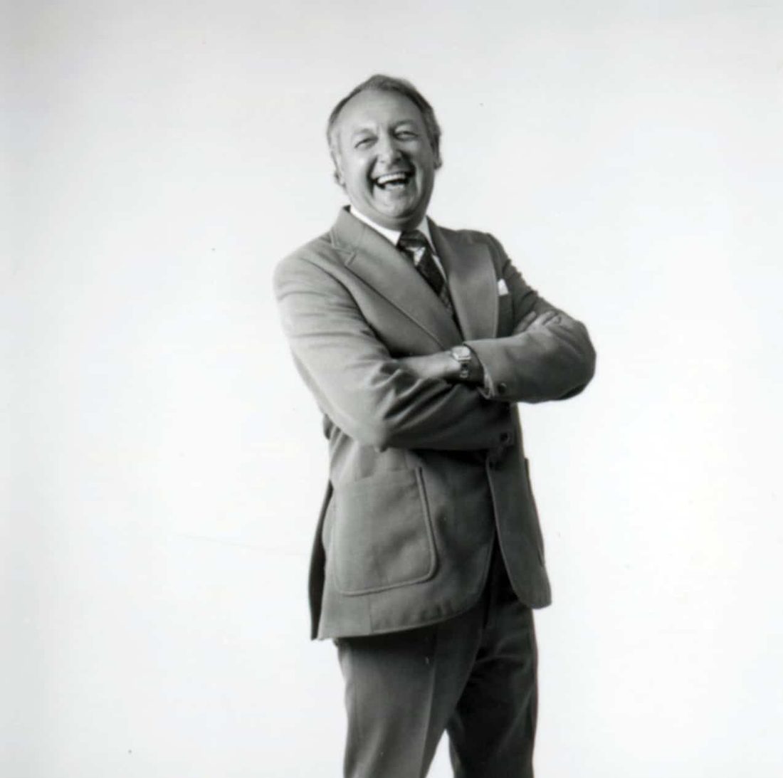 Sir Freddie Laker laughing, arms crossed, in a studio portrait
